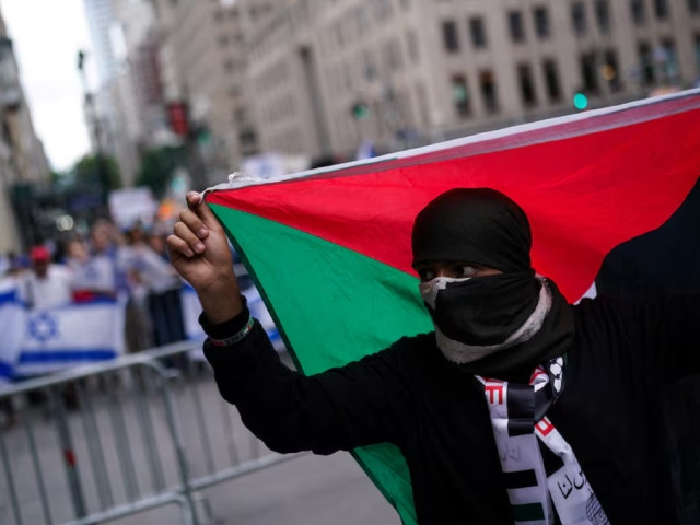 a pro palestinian supporter holds a palestinian flag as people protest against city university of new york cuny college allowing the filming of an fbi most wanted episode fictionalising a gaza solidarity encampment in new york city us july 22 2024 photo reuters a pro palestinian supporter holds a palestinian flag as people protest against city university of new york cuny college allowing the filming of an fbi most wanted episode fictionalising a gaza solidarity encampment in new york city us july 22 2024 photo reuters